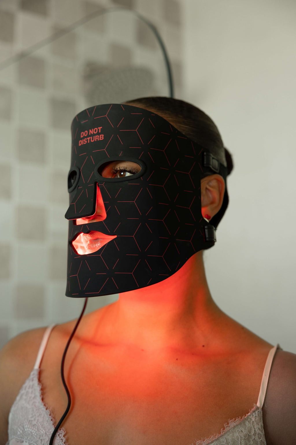 Woman wearing the illuminated Renew Red Light Mask