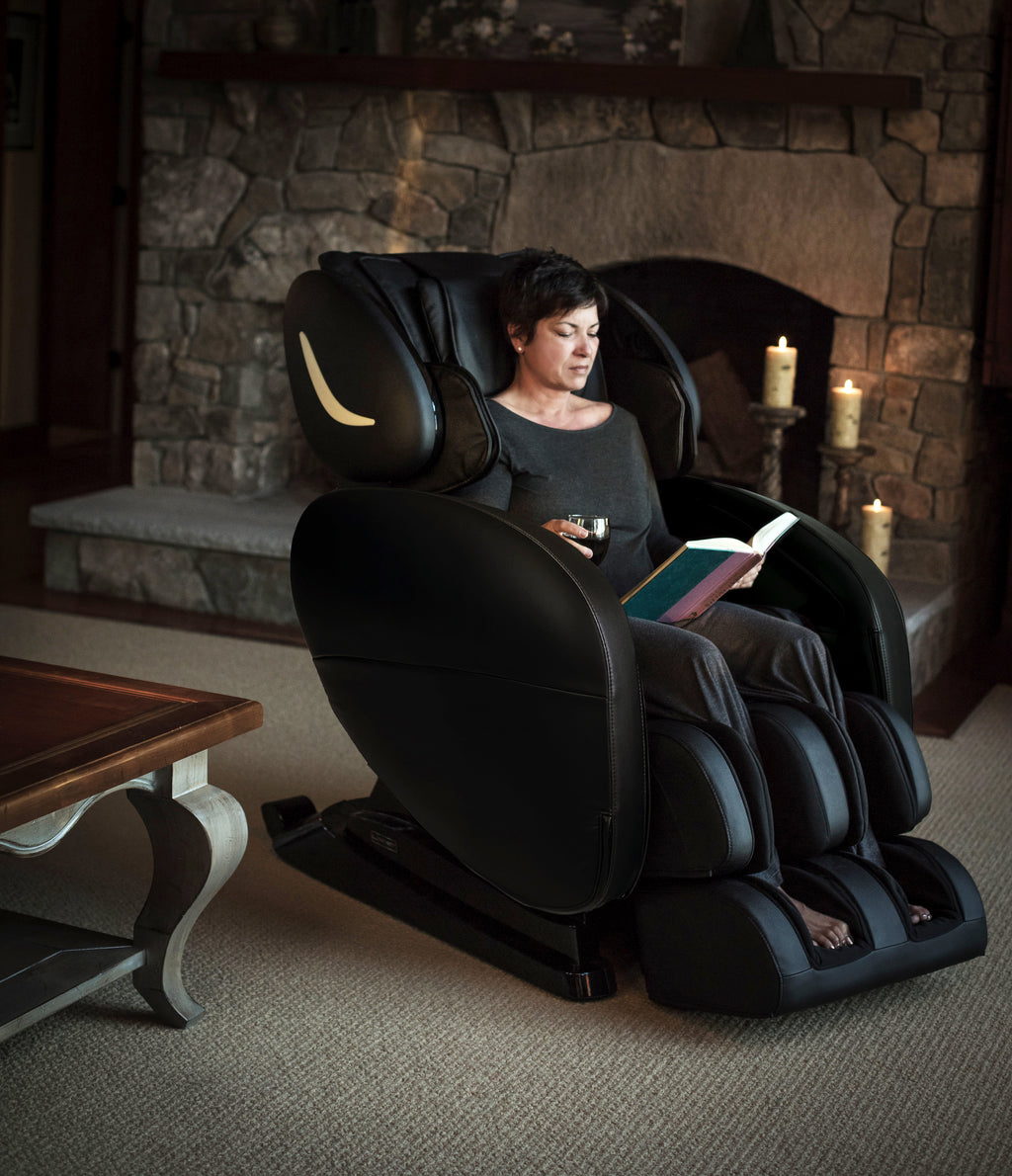 Reading beside the fireplace in the Infinity Smart Chair X3